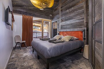A small bedroom with a bed and a chair