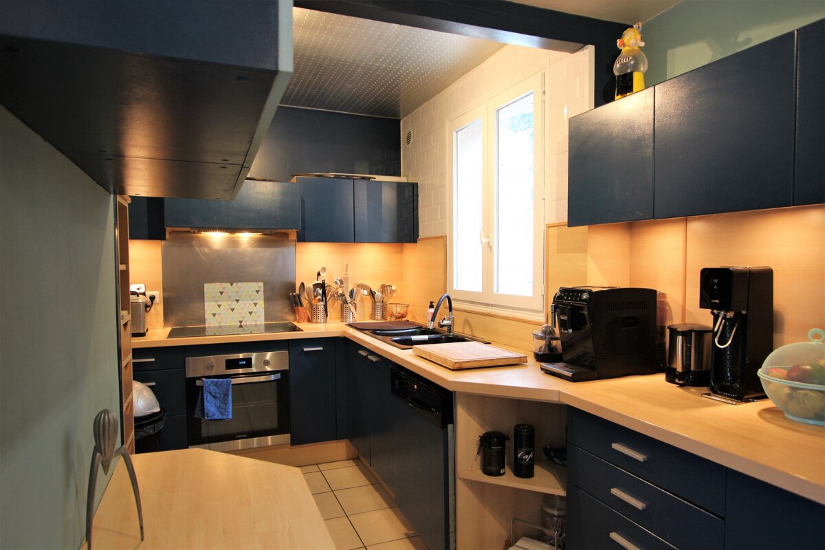 A kitchen with blue cabinets and a black coffee maker