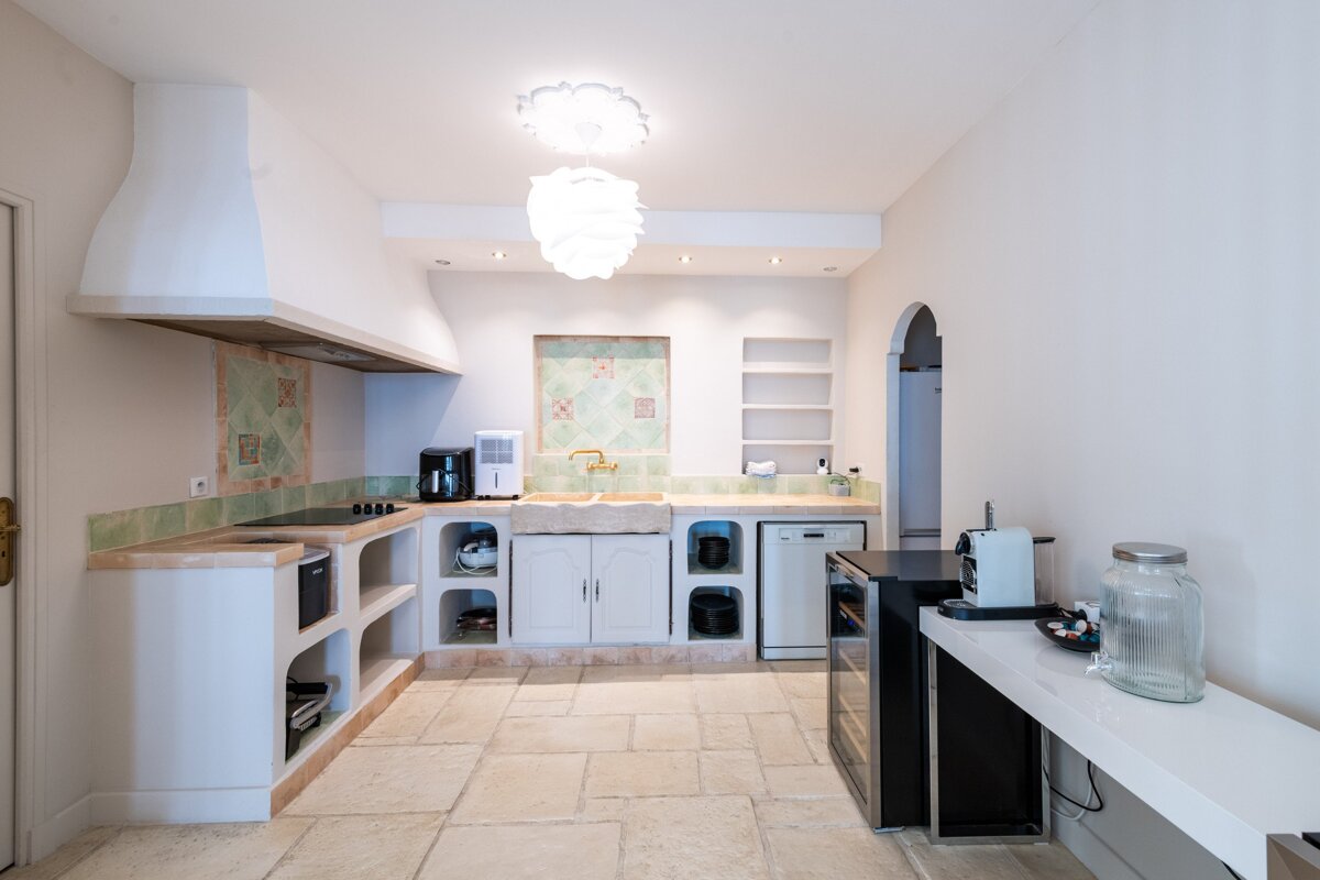 A kitchen with white cabinets and a black refrigerator