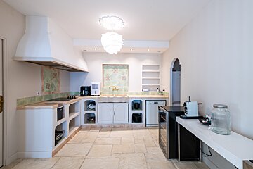 A kitchen with white cabinets and a black refrigerator