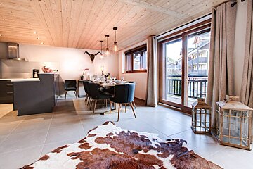 A dining room with a cowhide rug on the floor