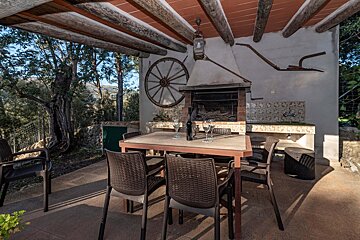 A table with chairs and a bottle of wine on it