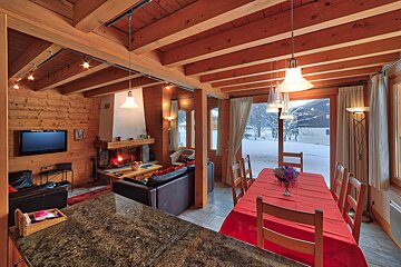 A living room with a fireplace and a dining table