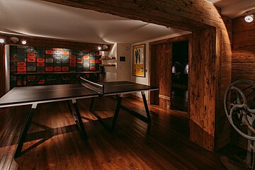 A room with a ping pong table and a poster on the wall