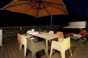 A table and chairs under an umbrella on a deck
