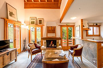 A living room with a fireplace and two chairs