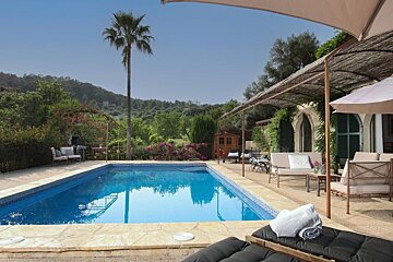 A large swimming pool surrounded by chairs and umbrellas