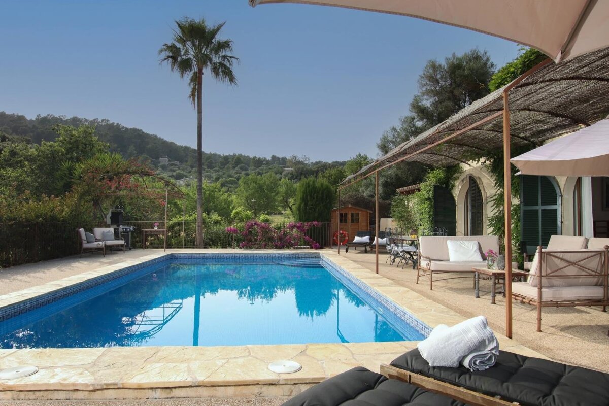 A large swimming pool surrounded by chairs and umbrellas