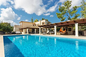 A large house with a large swimming pool in front of it