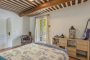 A bedroom with a bed a chair and a shelf with the word france on it
