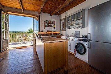 A kitchen with a stainless steel refrigerator and a washing machine