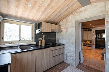 A kitchen with wooden cabinets and black counter tops