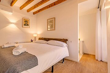 A bedroom with a bed and a picture on the wall