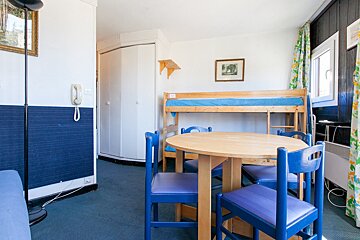 A room with a table and chairs and a bunk bed