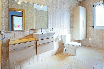 A bathroom with a toilet a sink and a mirror