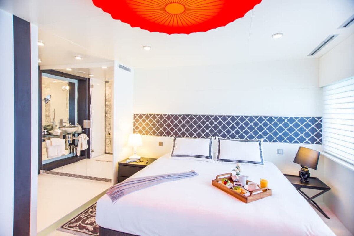 A hotel room with a tray of food on the bed