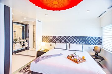 A hotel room with a tray of food on the bed