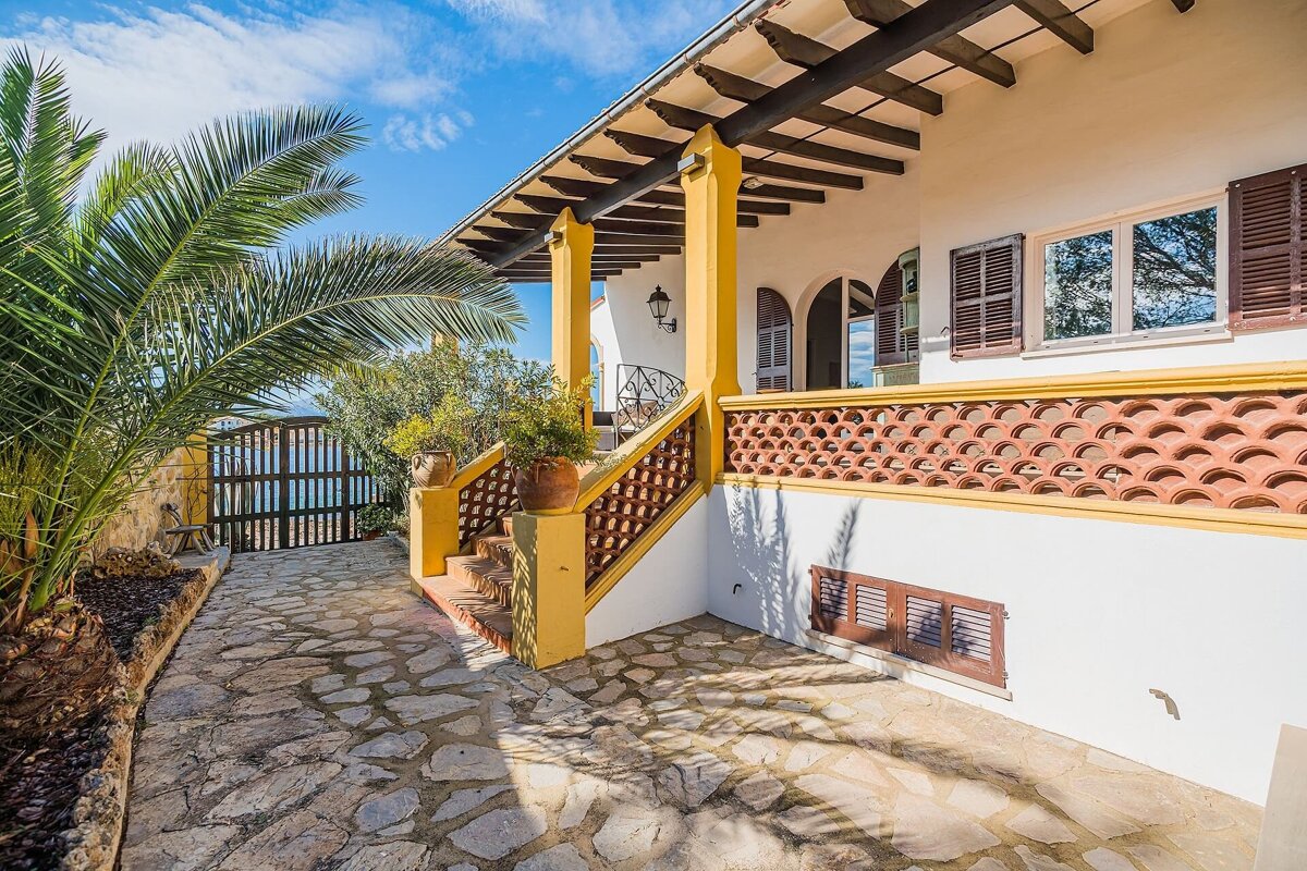 A white house with a yellow porch and stairs