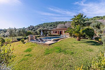 A house with a large swimming pool in front of it