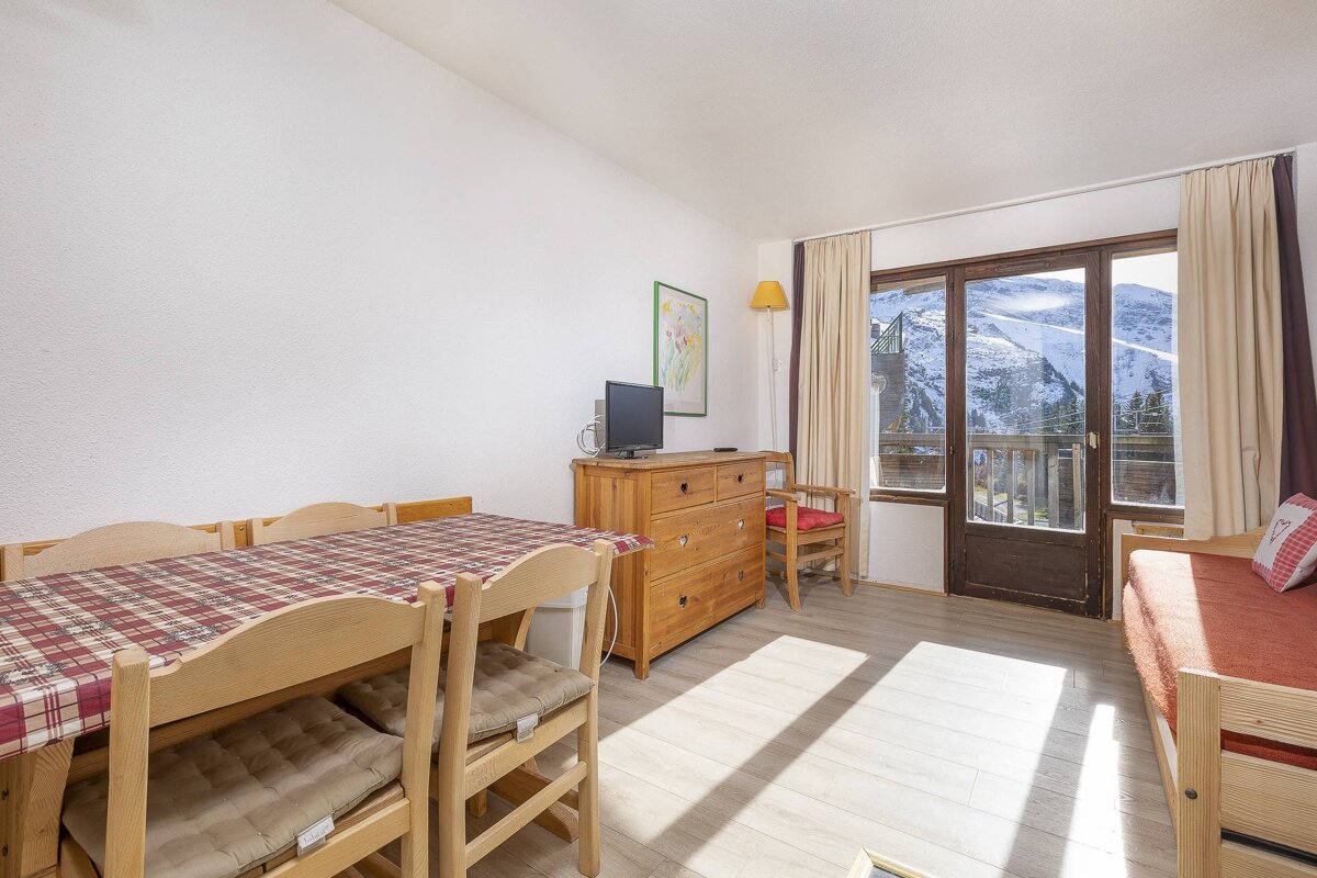 A living room with a table and chairs and a television