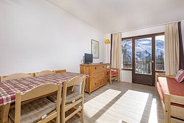 A living room with a table and chairs and a television