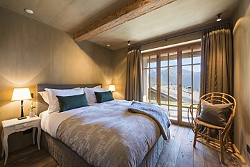 A bedroom with a large bed and a large window