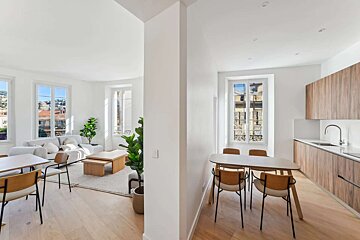 A living room with a table and chairs and a kitchen
