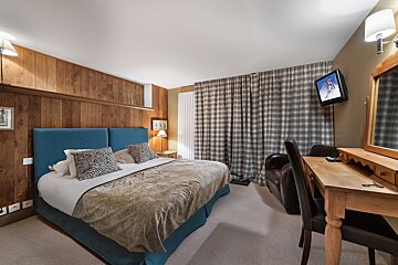 A hotel room with a large bed and a flat screen tv