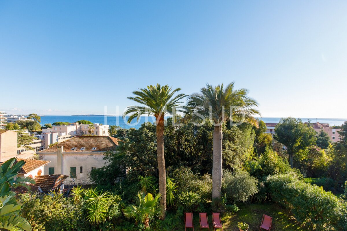 An aerial view of a lush green garden with palm trees and a sign that says home sub