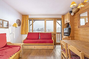 A living room with a red couch and a flat screen tv