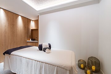 A bathroom with a sink and a round mirror