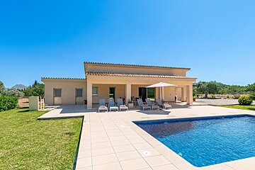 A house with a large swimming pool in front of it
