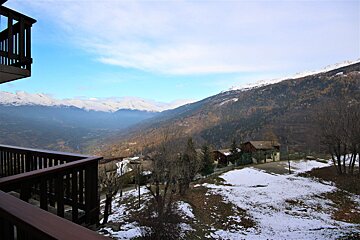 A view of a snowy mountain valley from a balcony