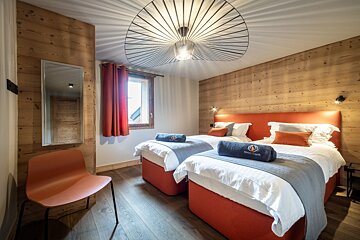 A hotel room with two beds and a chair