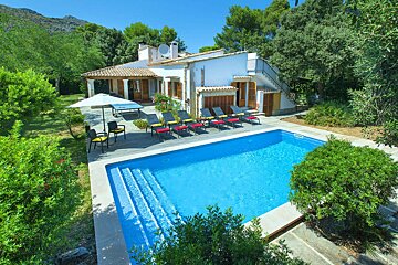 A house with a large swimming pool in front of it