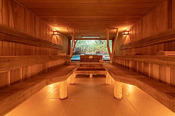 A wooden sauna with a picture of a river on the wall