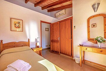 A bedroom with a single bed and a mirror