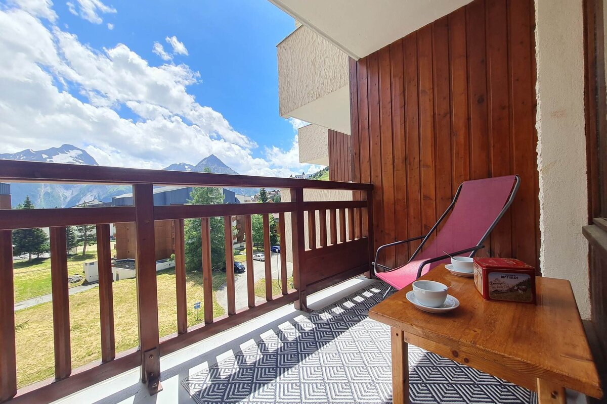 A balcony with a chair and a box of tea