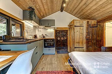 A bedroom with a bed and a kitchen with knight frank written on the wall