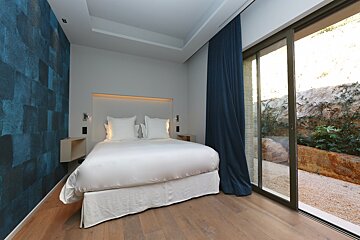 A bedroom with a bed and a sliding glass door