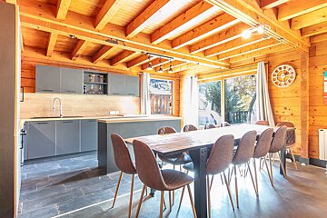 A kitchen with a table and chairs and a clock on the wall