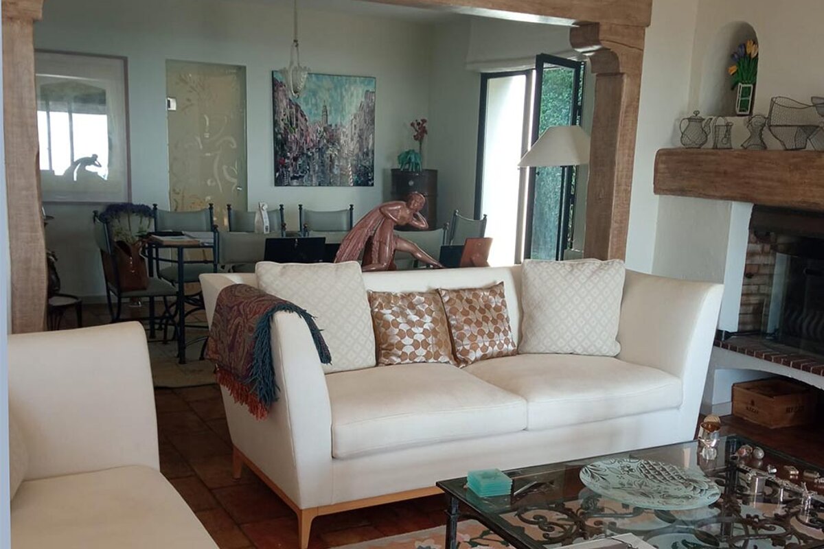 A living room with a white couch and a glass coffee table