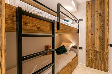 A bunk bed with a teddy bear on it