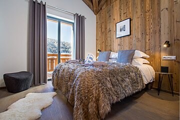 A bedroom with a fur blanket on the bed