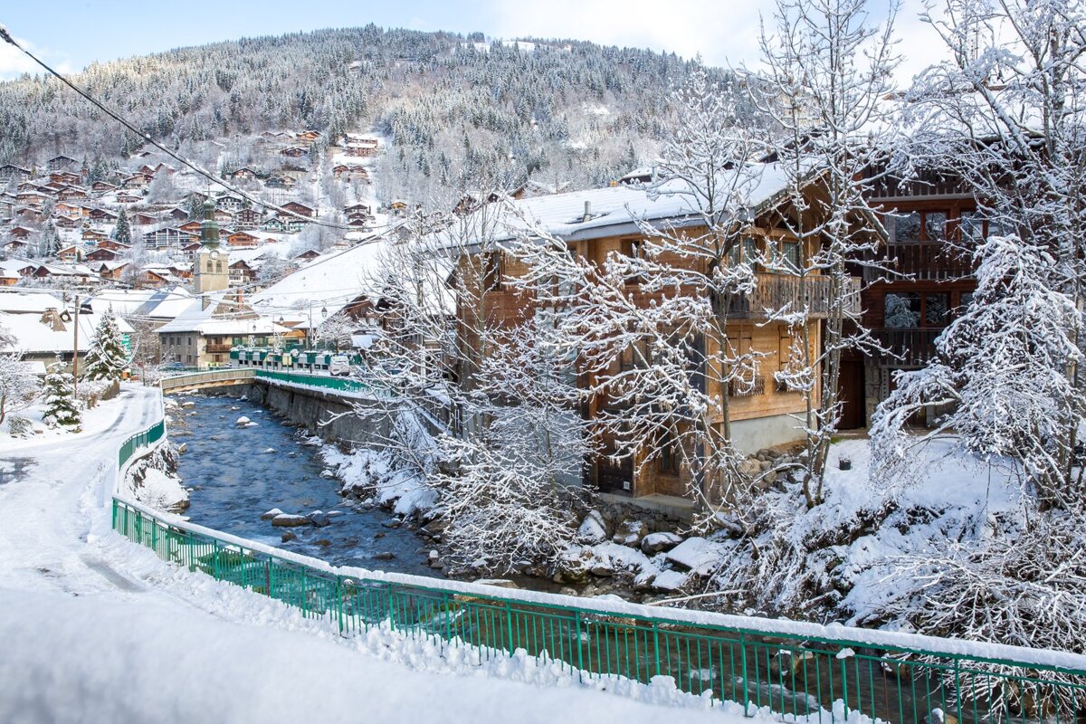 A bridge over a river in a snowy village