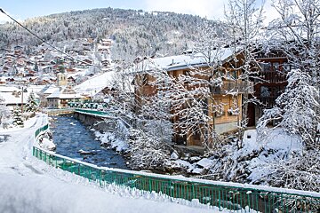 A bridge over a river in a snowy village