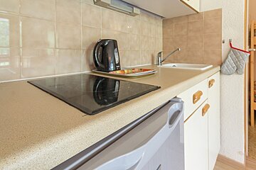 A kitchen counter with a stove top oven and a dishwasher