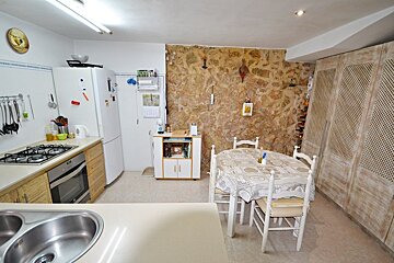 A kitchen with a table and chairs and a calendar on the wall