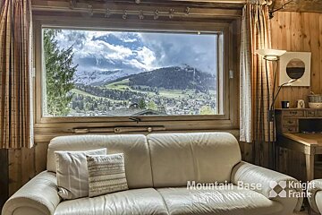 A couch in front of a window that says mountain base