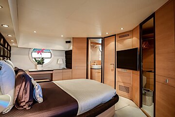 A bedroom with a round bed and a flat screen tv